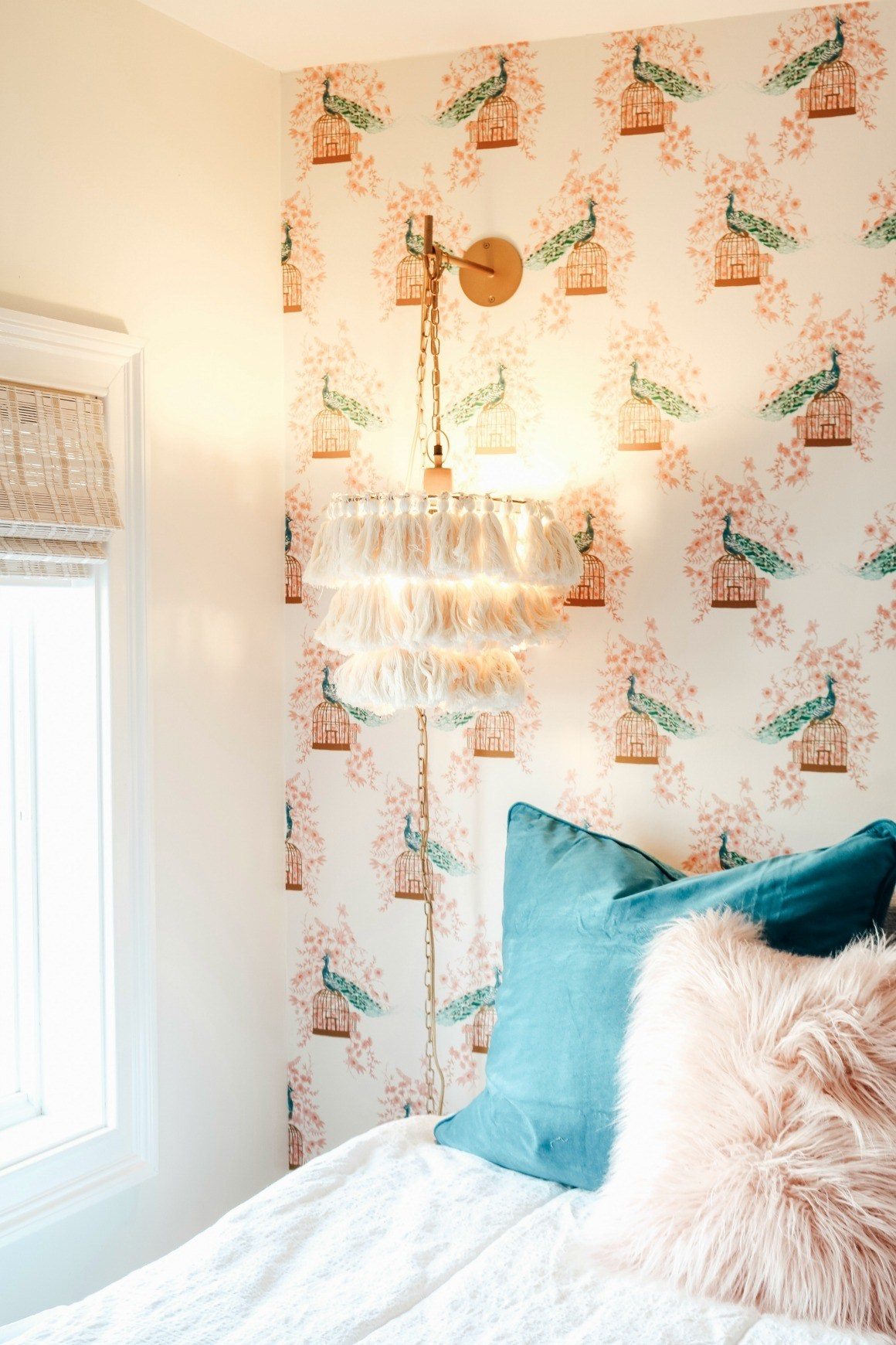 اتاق خوابی که دیوار پشت تخت آن کاغذ دیواری طرح پرنده دارد و دیوار کناری آن نقاشی شده است
